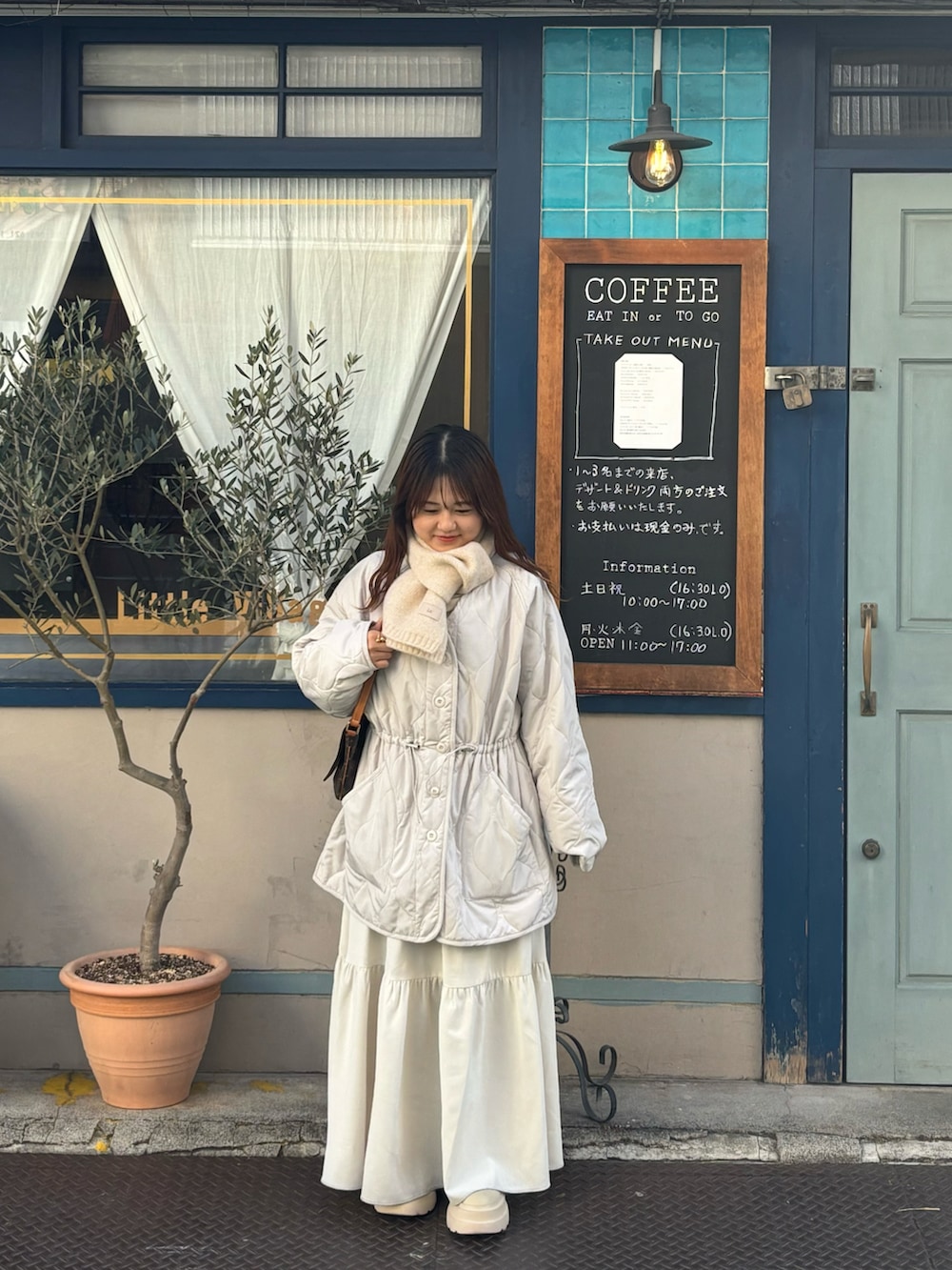 ホワイト系のノーカラージャケット、ホワイト系のマフラーを着用したレディースの冬コーディネートの2枚目の写真