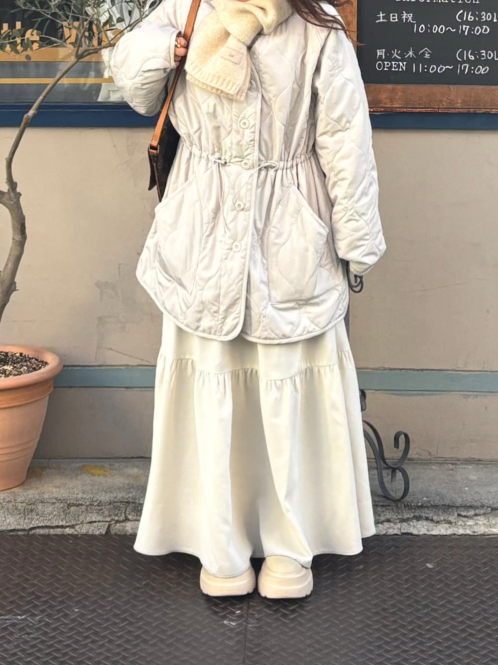 ホワイト系のノーカラージャケット、ホワイト系のマフラーを着用したレディースの冬コーディネートの3枚目の写真