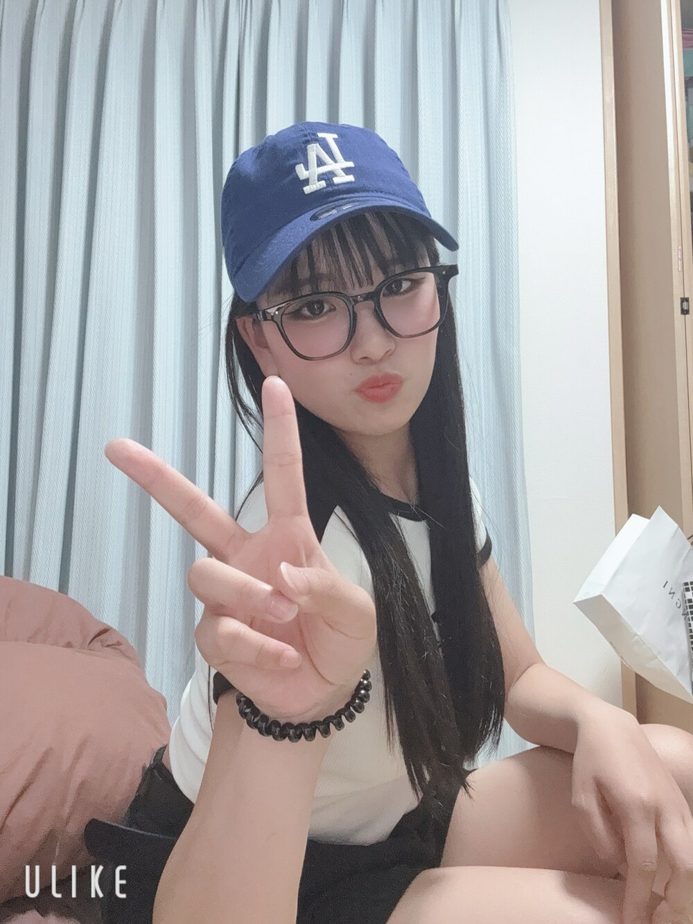 ホワイト系のTシャツ/カットソー、ブルー系のキャップ、ブラック系のメガネを着用したレディースの夏コーディネートの2枚目の写真