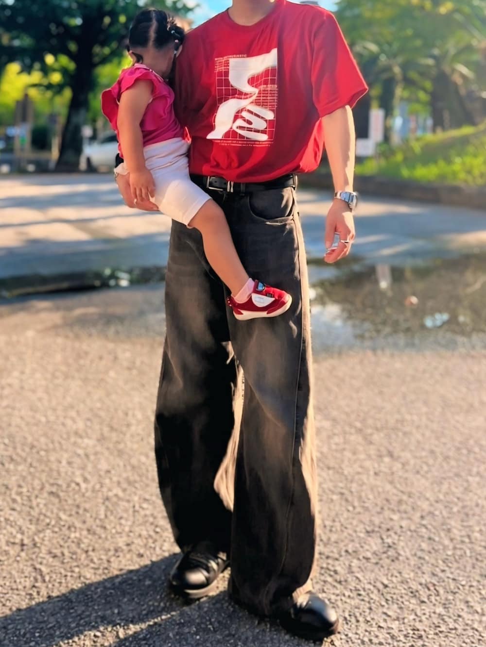 レッド系のTシャツ/カットソー、ブラック系のデニムパンツ、シルバー系のリングを着用したメンズの秋コーディネートの3枚目の写真