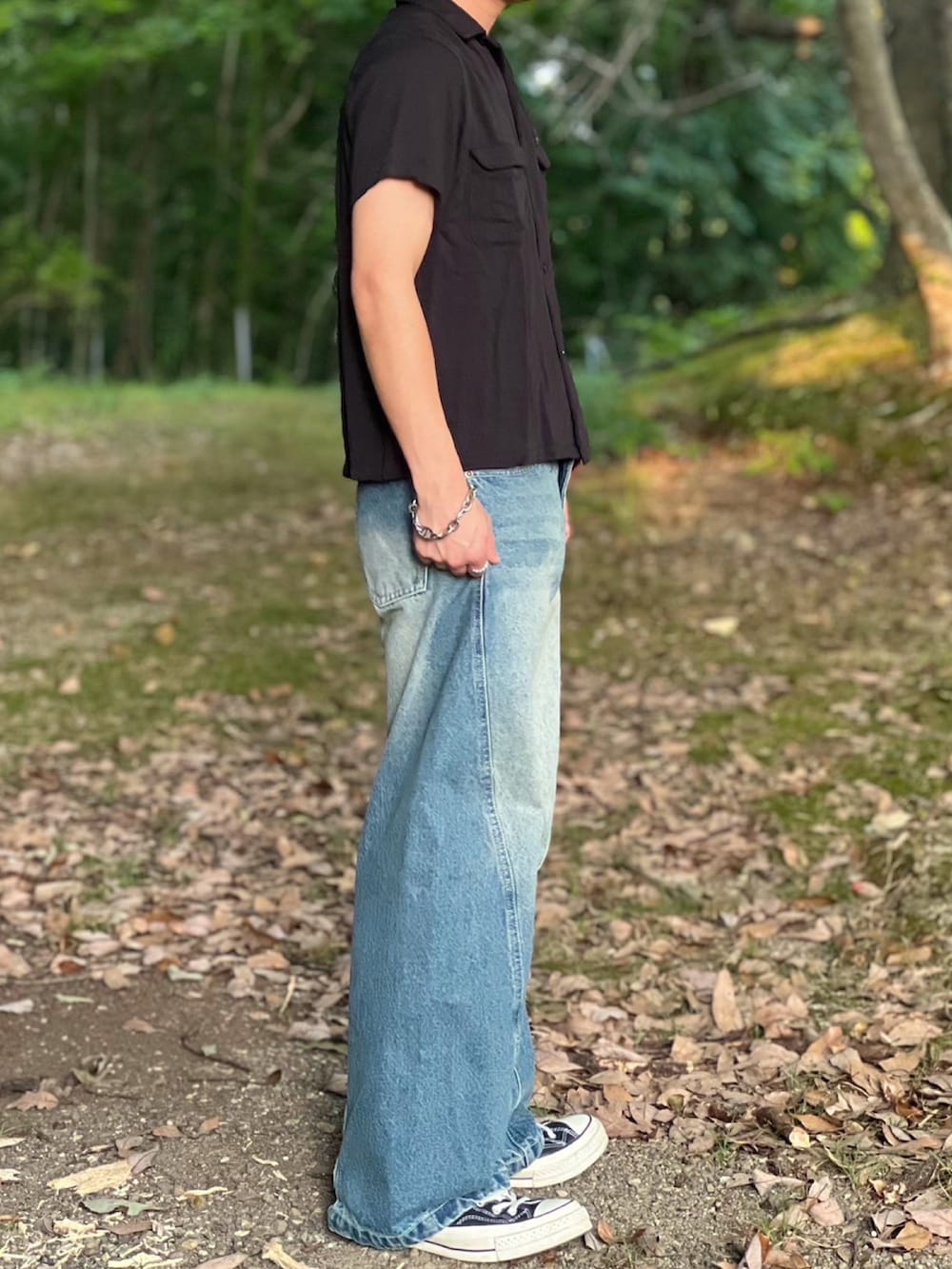 ブルー系のデニムパンツ、ブラック系のハンドバッグ、ブラック系のシャツ/ブラウスを着用したメンズの夏コーディネートの4枚目の写真