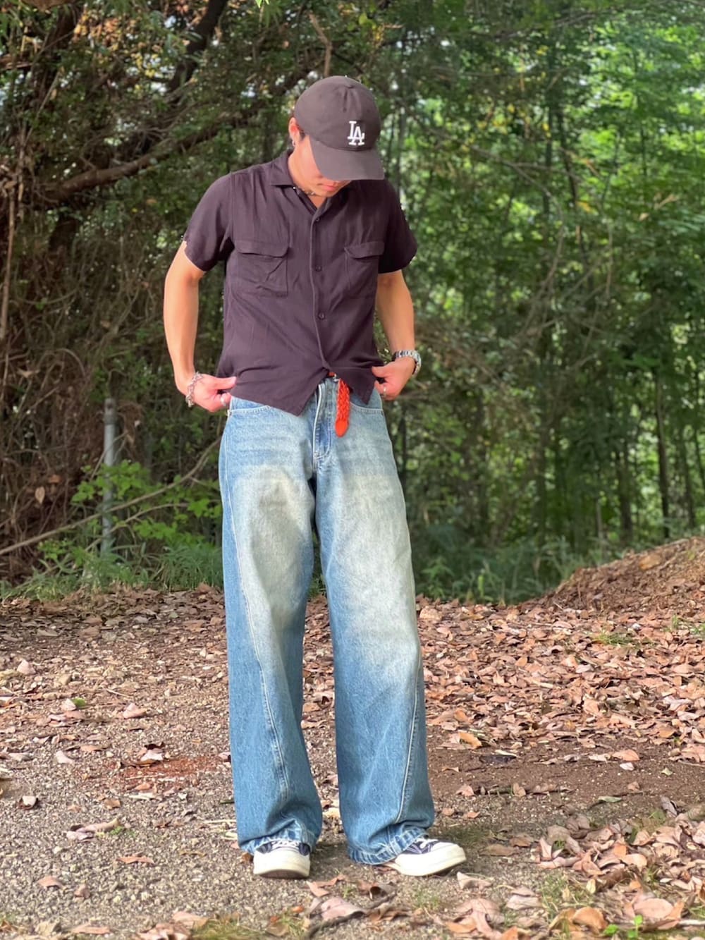 ブルー系のデニムパンツ、ブラック系のハンドバッグ、ブラック系のシャツ/ブラウスを着用したメンズの夏コーディネートの3枚目の写真