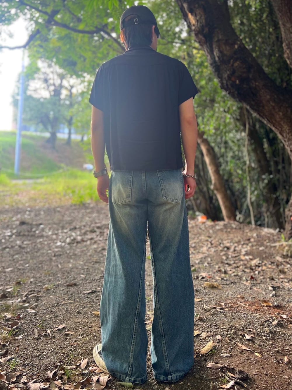 ブルー系のデニムパンツ、ブラック系のハンドバッグ、ブラック系のシャツ/ブラウスを着用したメンズの夏コーディネートの5枚目の写真