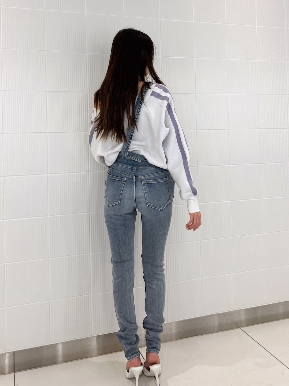 ホワイト系のパンプス、ブルー系のつなぎ/オールインワン、ホワイト系のニット/セーターを着用したレディースの冬コーディネートの3枚目の写真