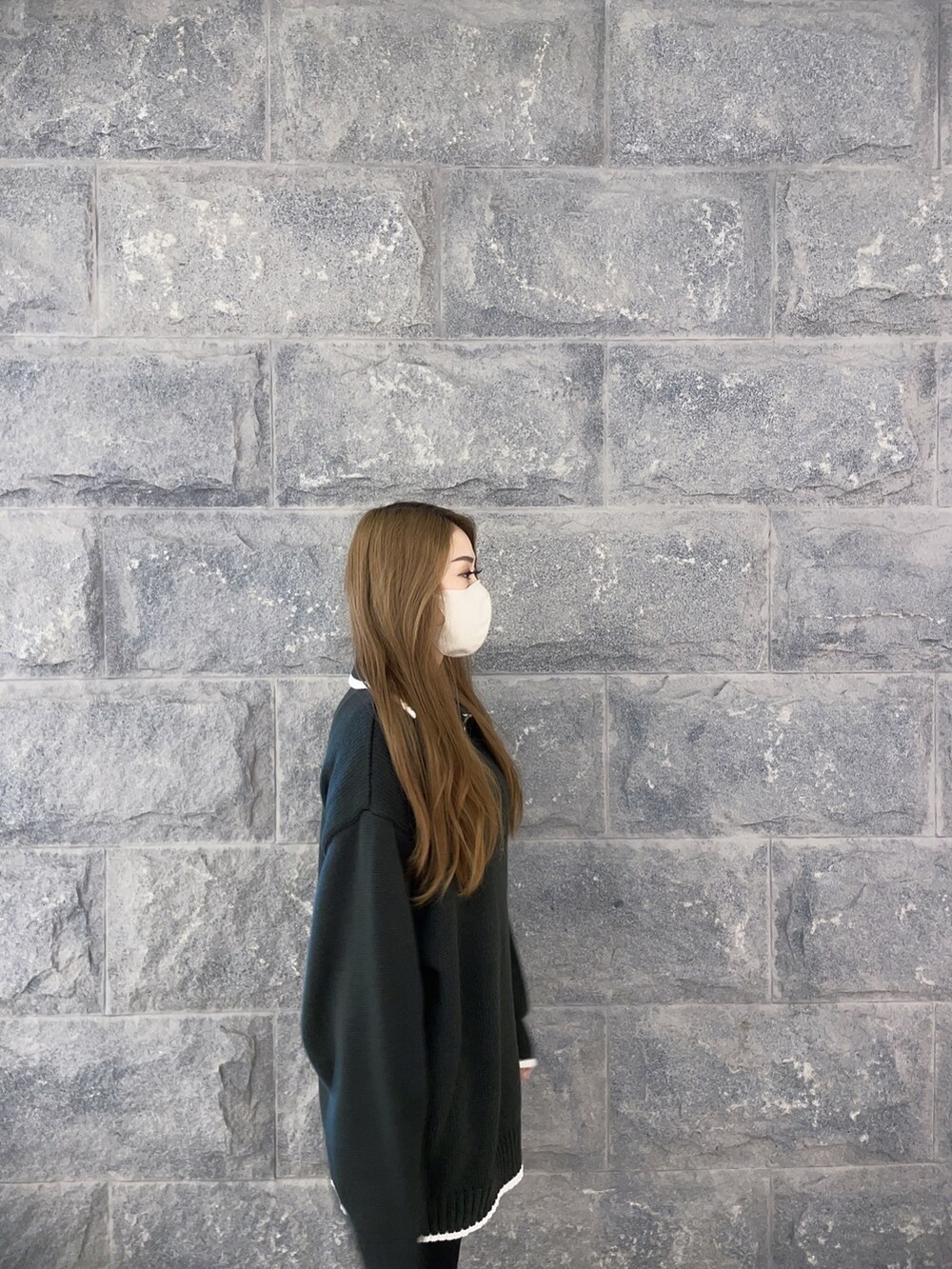 ホワイト系のニット/セーター、ブラック系のデニムパンツ、ホワイト系のパンプスを着用したレディースの冬コーディネートの3枚目の写真