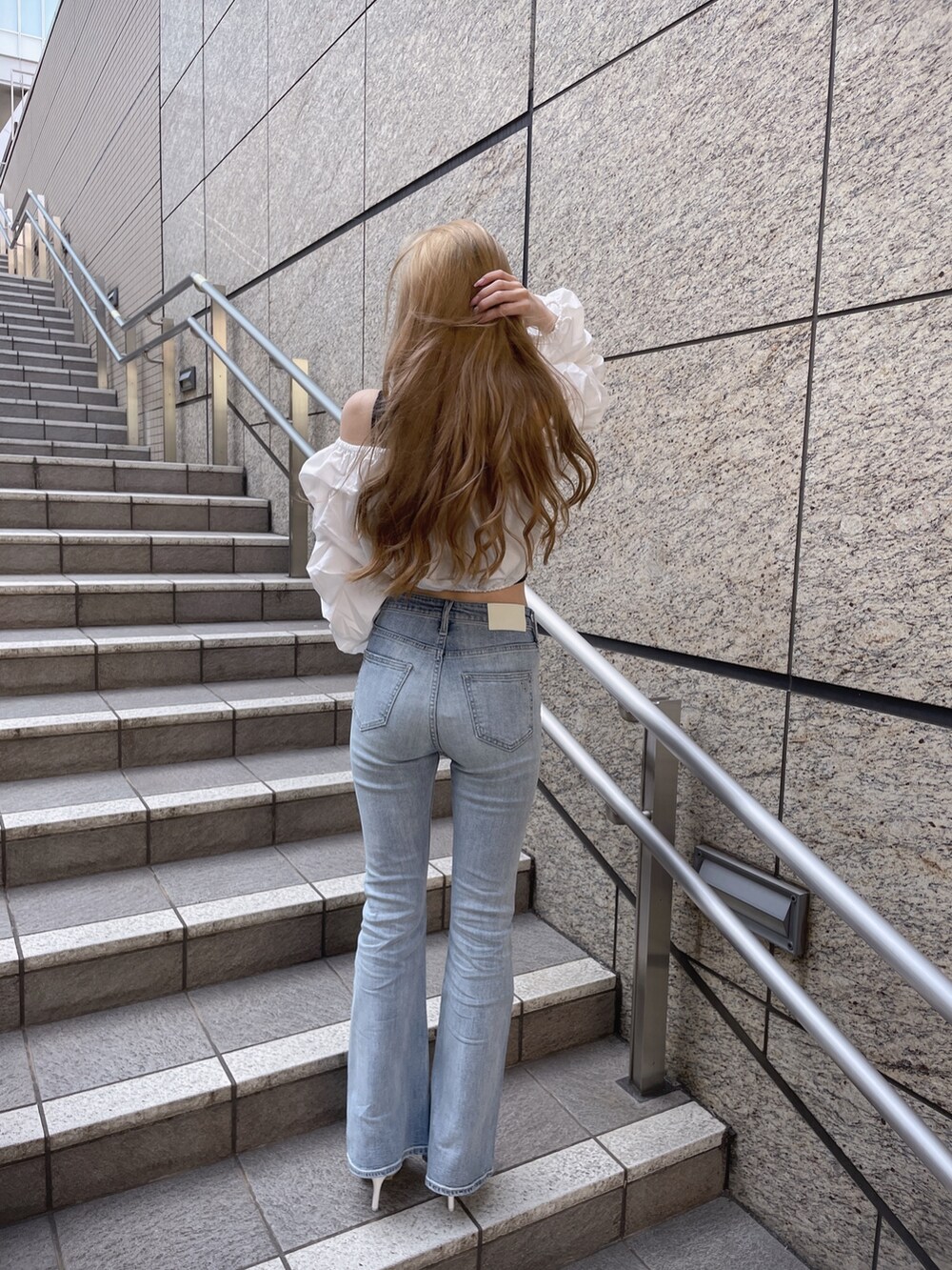 ホワイト系のパンプス、ブルー系のデニムパンツ、ホワイト系のシャツ/ブラウスを着用したレディースの春コーディネートの3枚目の写真