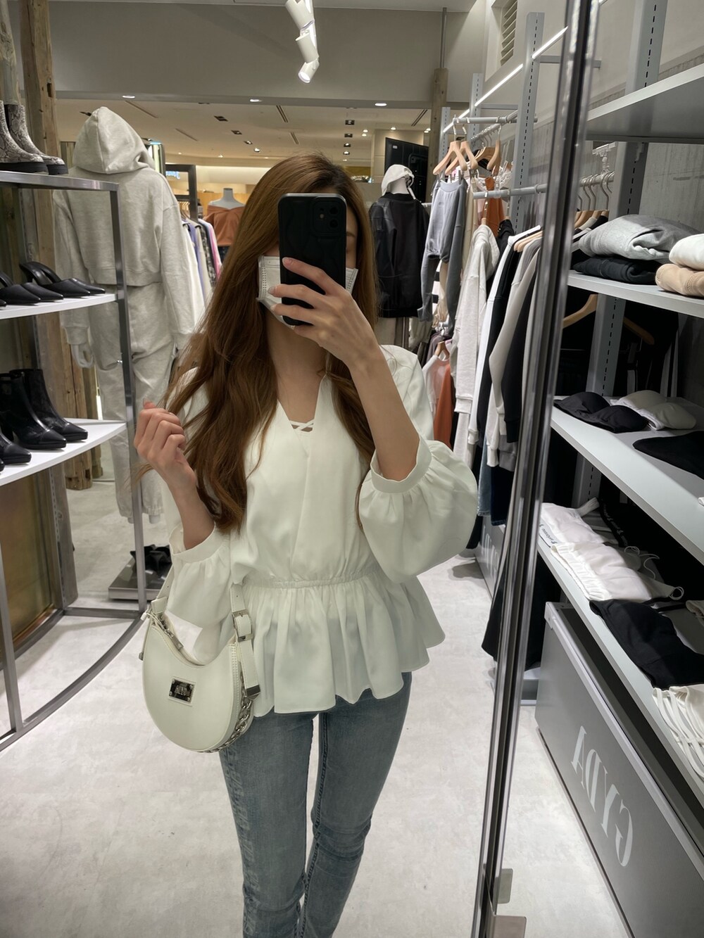 ホワイト系のシャツ/ブラウス、ブルー系のデニムパンツ、ホワイト系のパンプスを着用したレディースの冬コーディネートの5枚目の写真