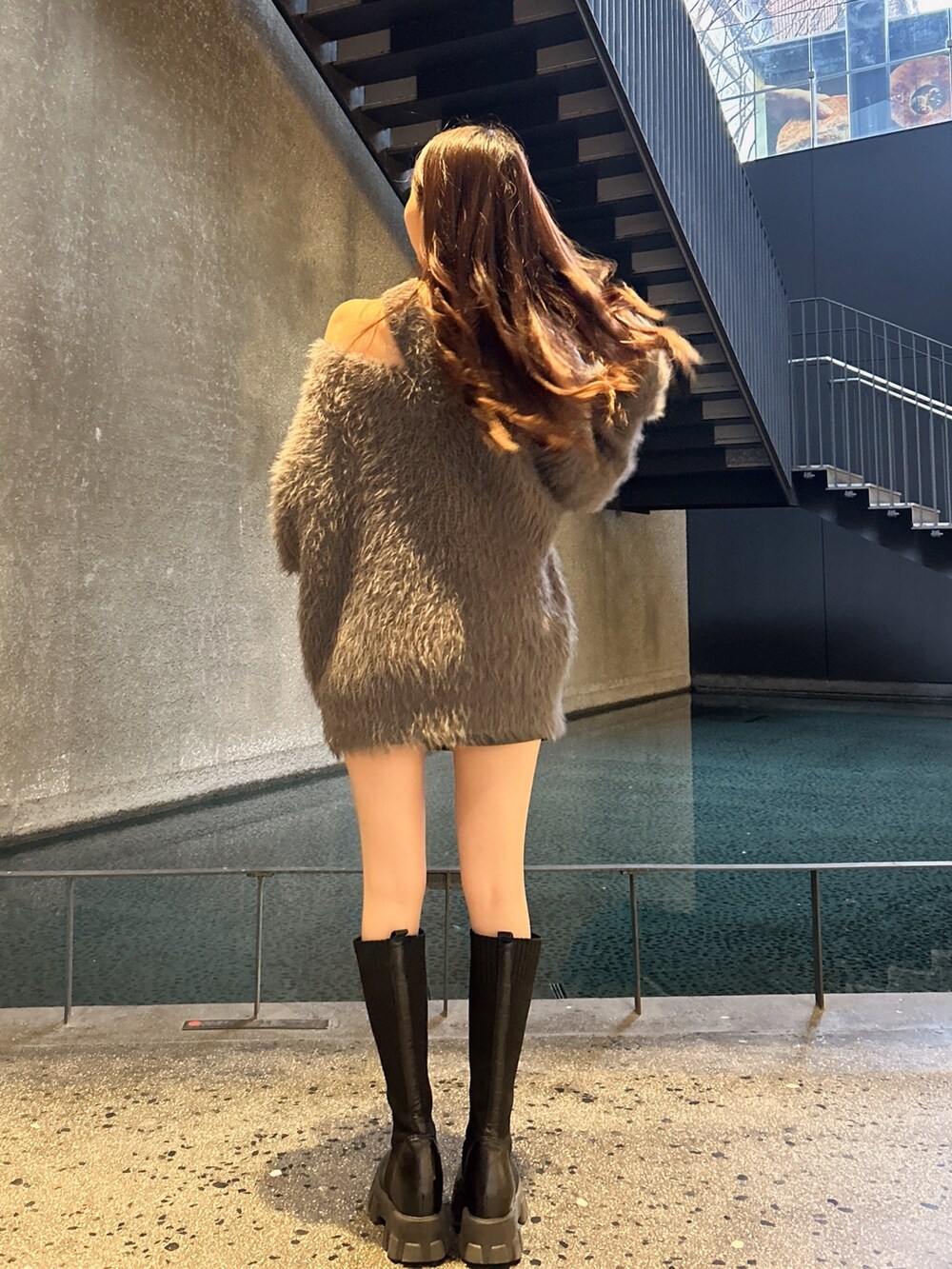 ブラック系のその他シューズ、グレー系のニット/セーター、ブラック系のスカートを着用したレディースの冬コーディネートの2枚目の写真