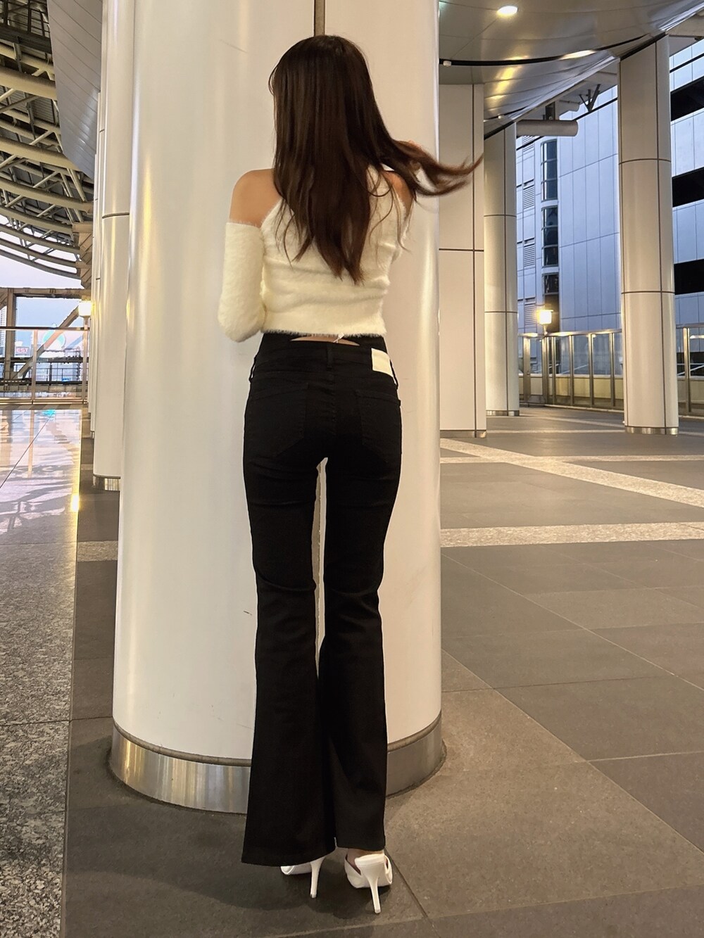 ホワイト系のムートンコート、ホワイト系のニット/セーター、ブラック系のデニムパンツを着用したレディースの秋コーディネートの8枚目の写真