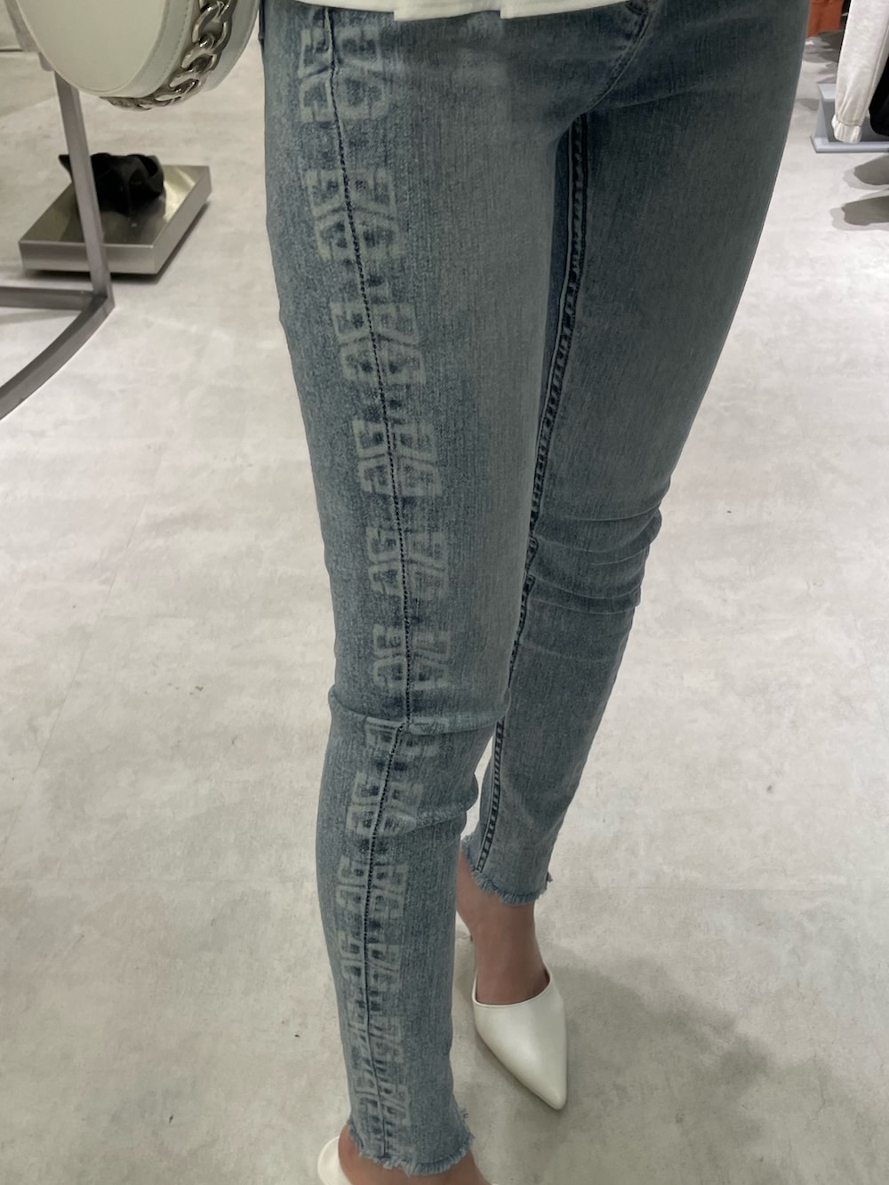 ホワイト系のシャツ/ブラウス、ブルー系のデニムパンツ、ホワイト系のパンプスを着用したレディースの冬コーディネートの6枚目の写真