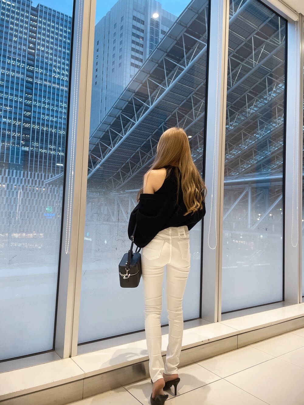 ブラック系のカーディガン/ボレロ、ホワイト系のデニムパンツ、ホワイト系のパンプスを着用したレディースの春コーディネートの2枚目の写真