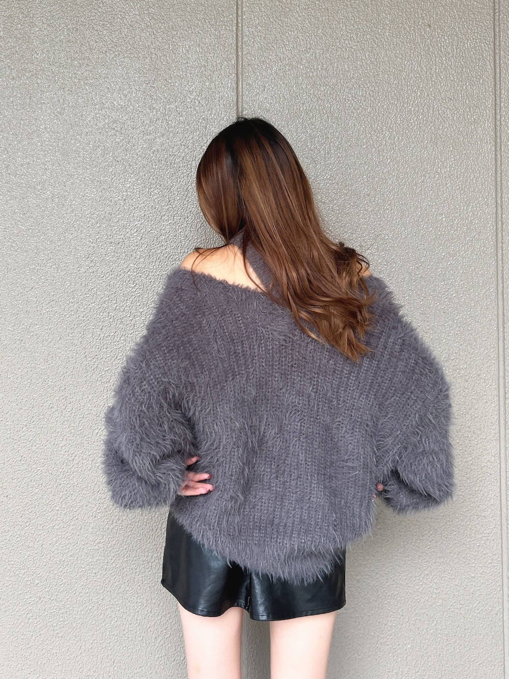 グレー系のニット/セーター、ブラック系のスカート、ブラック系のブーツを着用したレディースの秋コーディネートの7枚目の写真