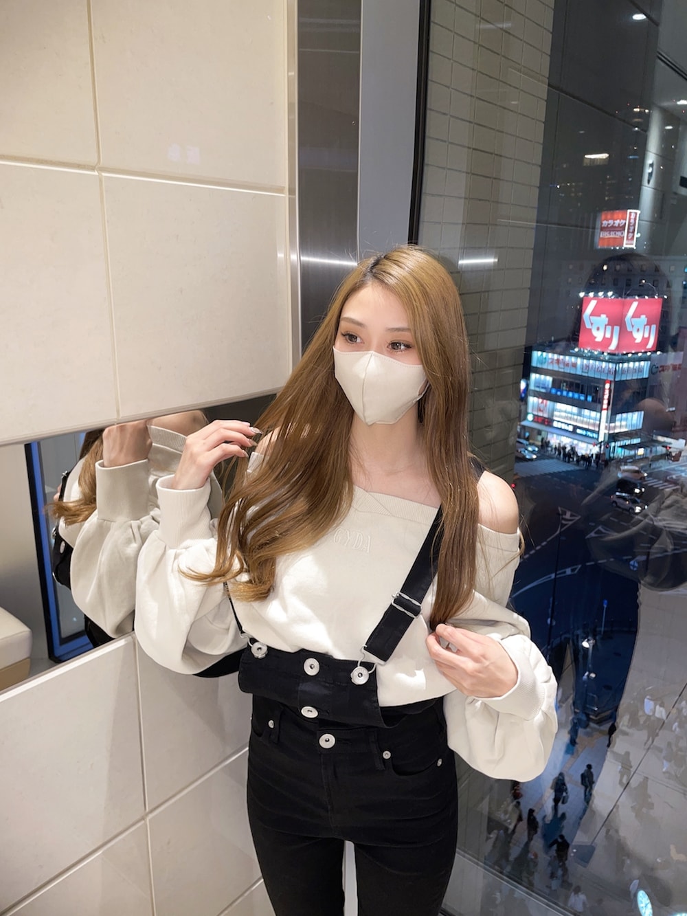 ホワイト系のTシャツ/カットソー、ブラック系のサロペット/オーバーオール、ホワイト系のパンプスを着用したレディースの冬コーディネートの5枚目の写真