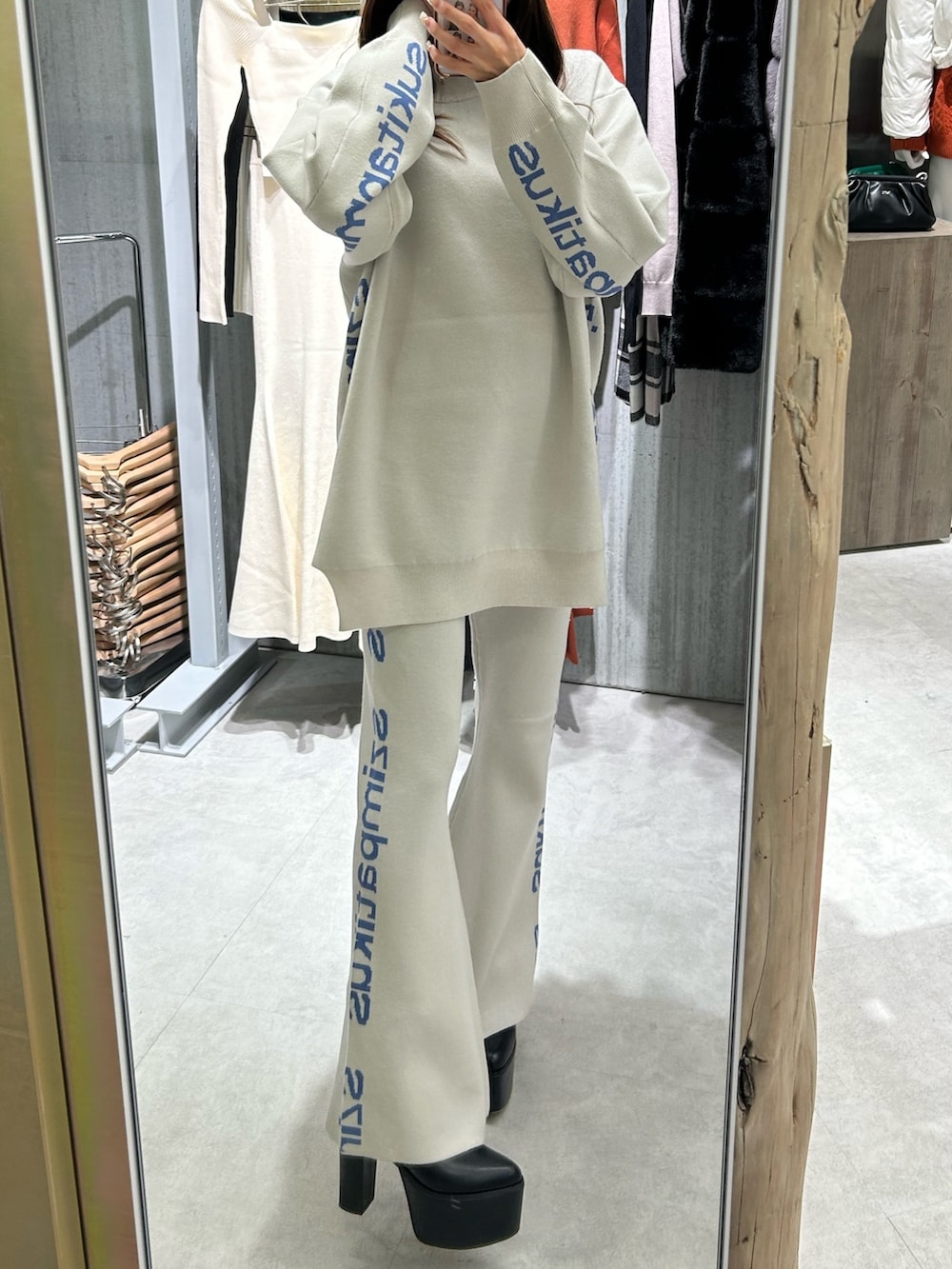 ホワイト系のニット/セーター、オレンジ系のその他パンツ、ブラック系のブーツを着用したレディースの冬コーディネートの9枚目の写真