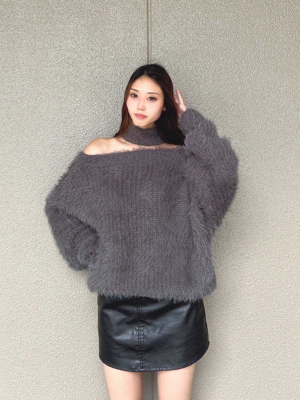 グレー系のニット/セーター、ブラック系のスカート、ブラック系のブーツを着用したレディースの秋コーディネートの4枚目の写真