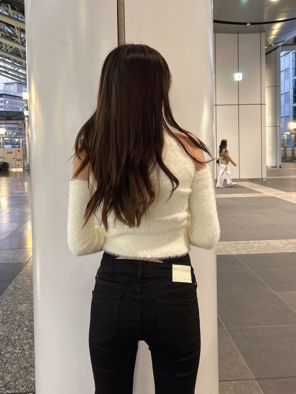 ホワイト系のムートンコート、ホワイト系のニット/セーター、ブラック系のデニムパンツを着用したレディースの秋コーディネートの10枚目の写真