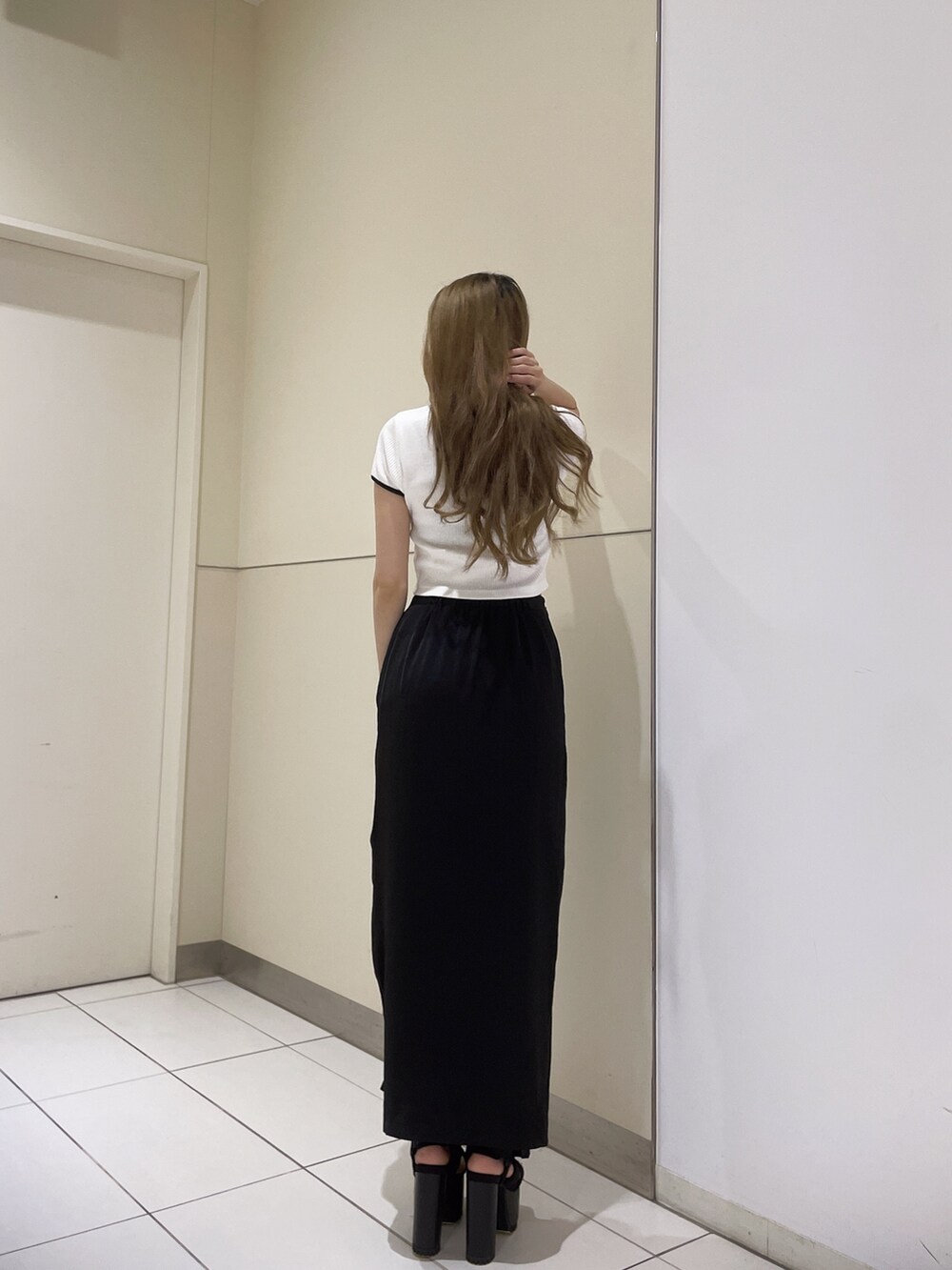 ホワイト系のTシャツ/カットソー、ブラック系のサンダル、ブラック系のスカートを着用したレディースの春コーディネートの3枚目の写真