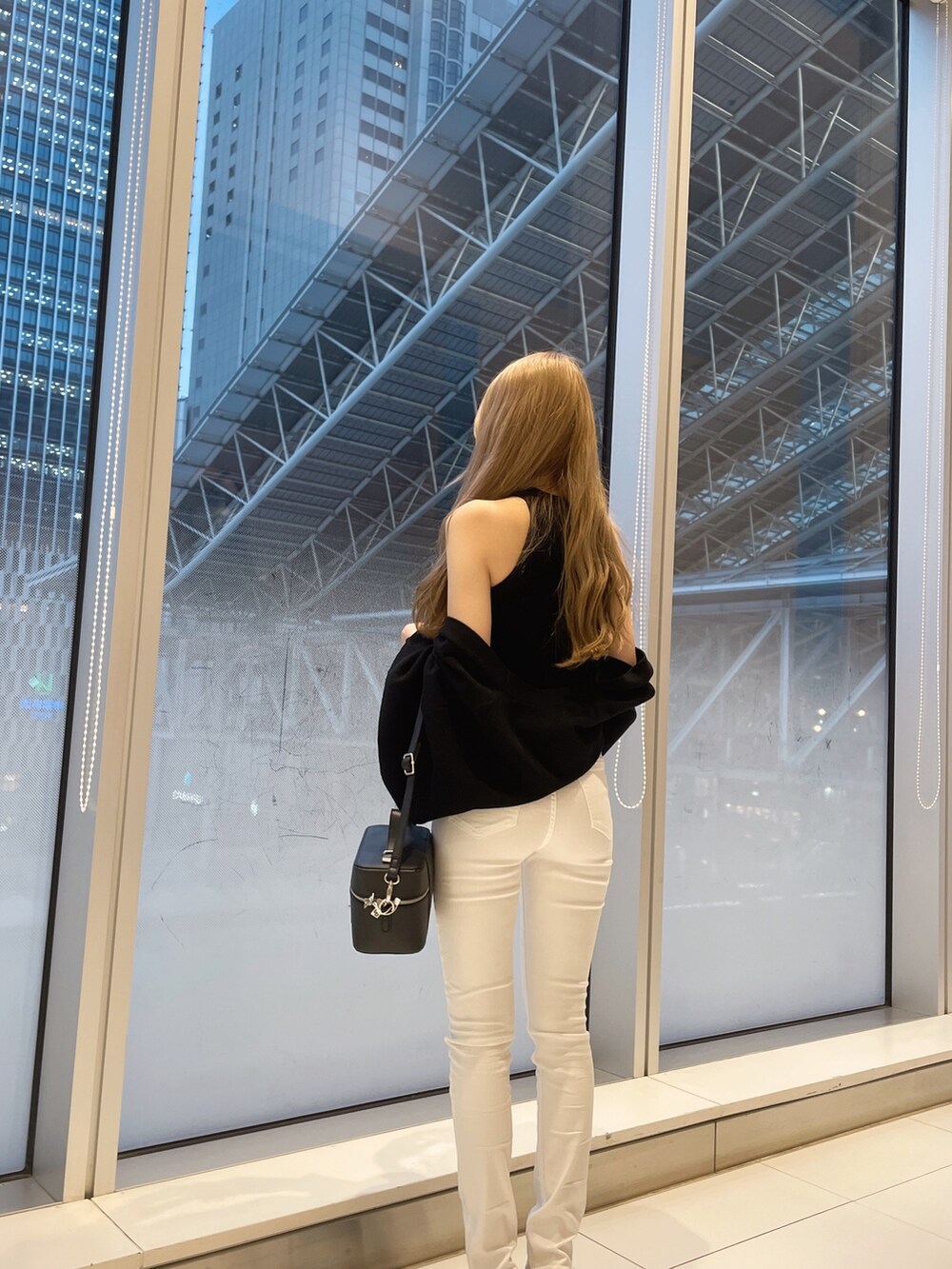 ブラック系のカーディガン/ボレロ、ホワイト系のデニムパンツ、ホワイト系のパンプスを着用したレディースの春コーディネートの4枚目の写真