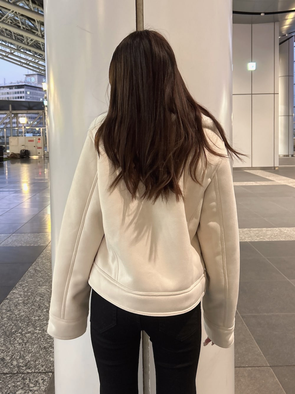 ホワイト系のムートンコート、ホワイト系のニット/セーター、ブラック系のデニムパンツを着用したレディースの秋コーディネートの4枚目の写真