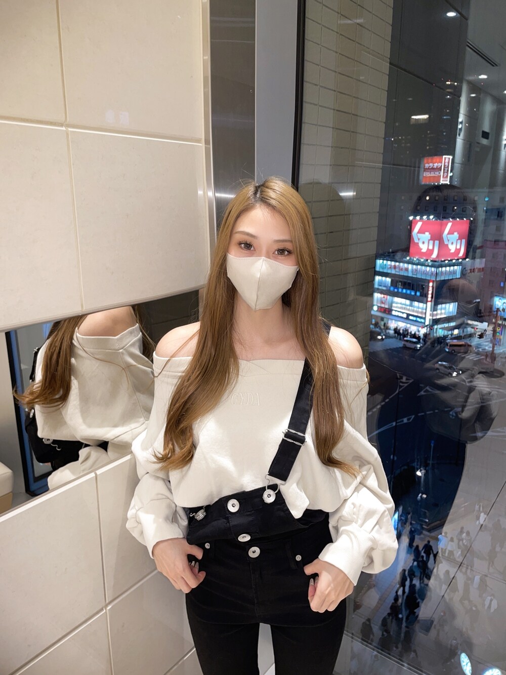 ホワイト系のTシャツ/カットソー、ブラック系のサロペット/オーバーオール、ホワイト系のパンプスを着用したレディースの冬コーディネートの6枚目の写真
