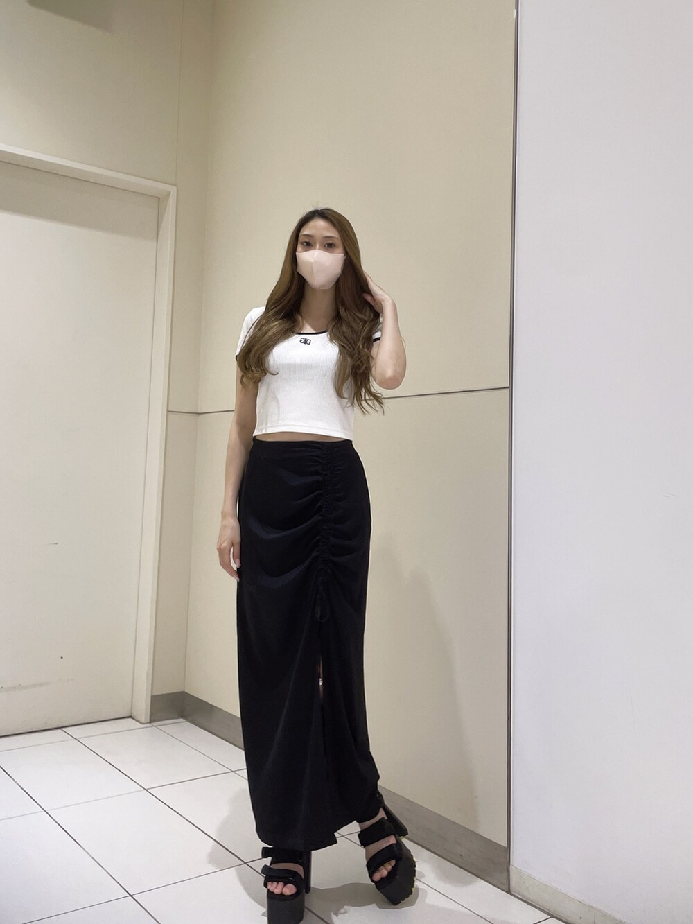 ホワイト系のTシャツ/カットソー、ブラック系のサンダル、ブラック系のスカートを着用したレディースの春コーディネートの4枚目の写真