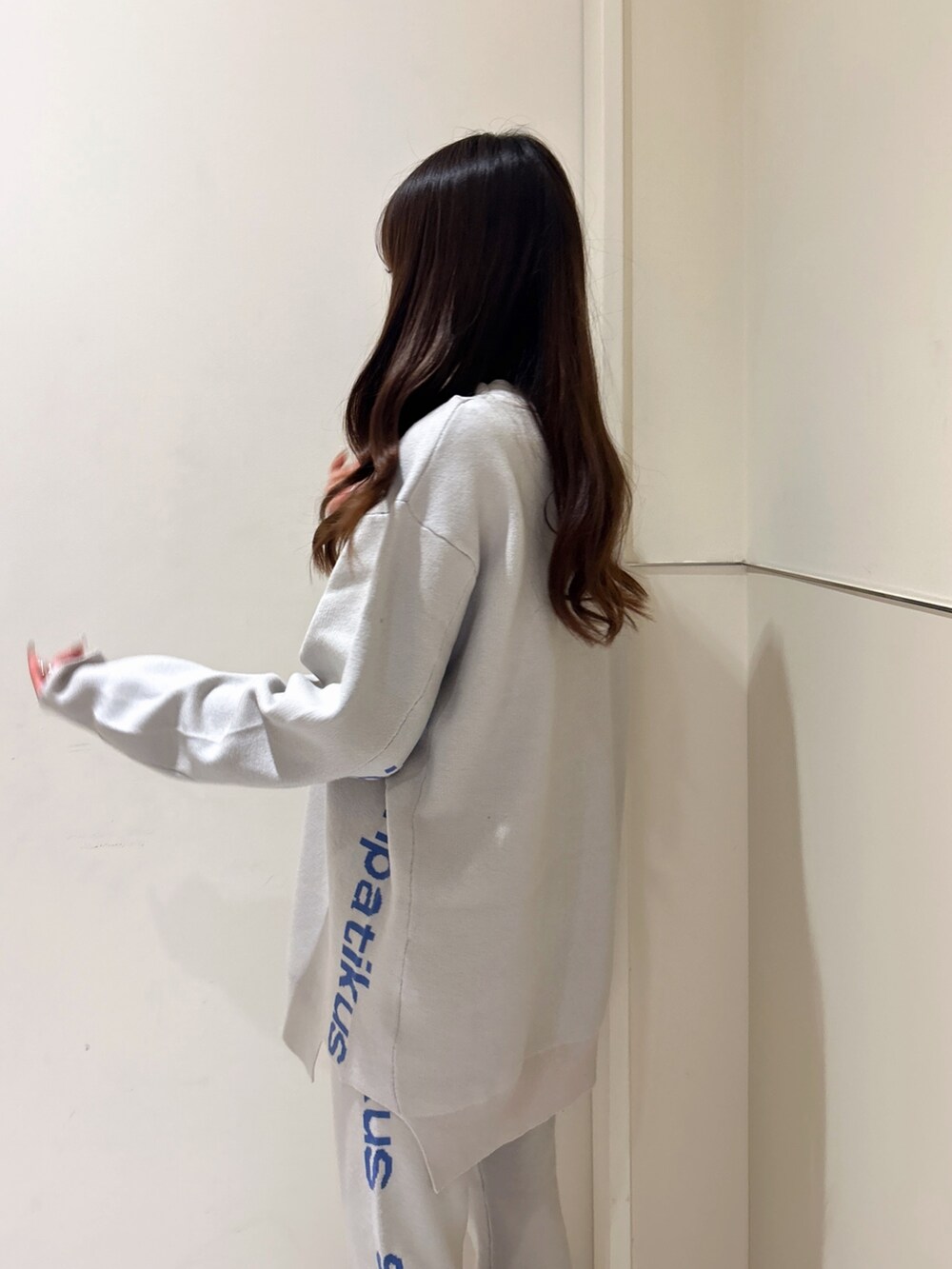 ホワイト系のニット/セーター、オレンジ系のその他パンツ、ブラック系のブーツを着用したレディースの冬コーディネートの6枚目の写真