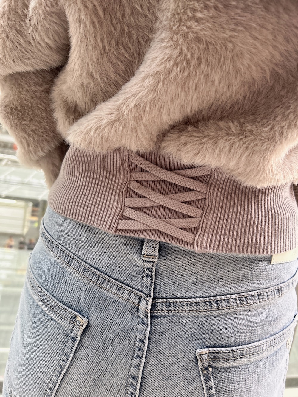 ベージュ系のニット/セーター、ブルー系のデニムパンツ、ブラック系のパンプスを着用したレディースの秋コーディネートの7枚目の写真