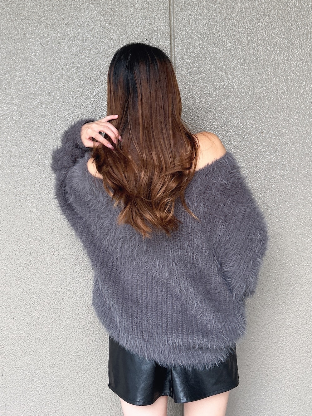 グレー系のニット/セーター、ブラック系のスカート、ブラック系のブーツを着用したレディースの秋コーディネートの6枚目の写真