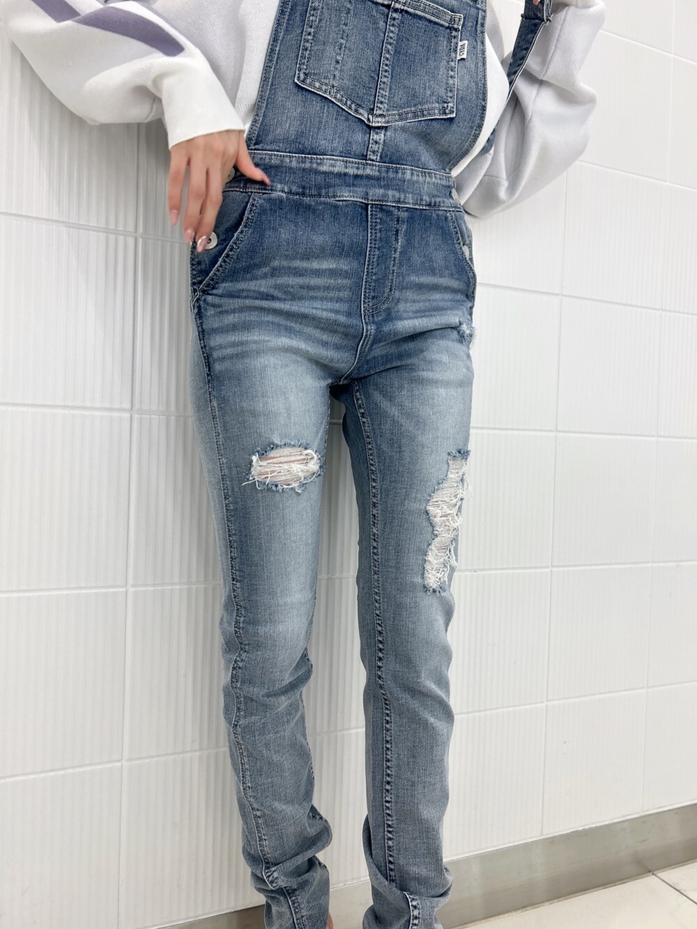 ホワイト系のパンプス、ブルー系のつなぎ/オールインワン、ホワイト系のニット/セーターを着用したレディースの冬コーディネートの9枚目の写真