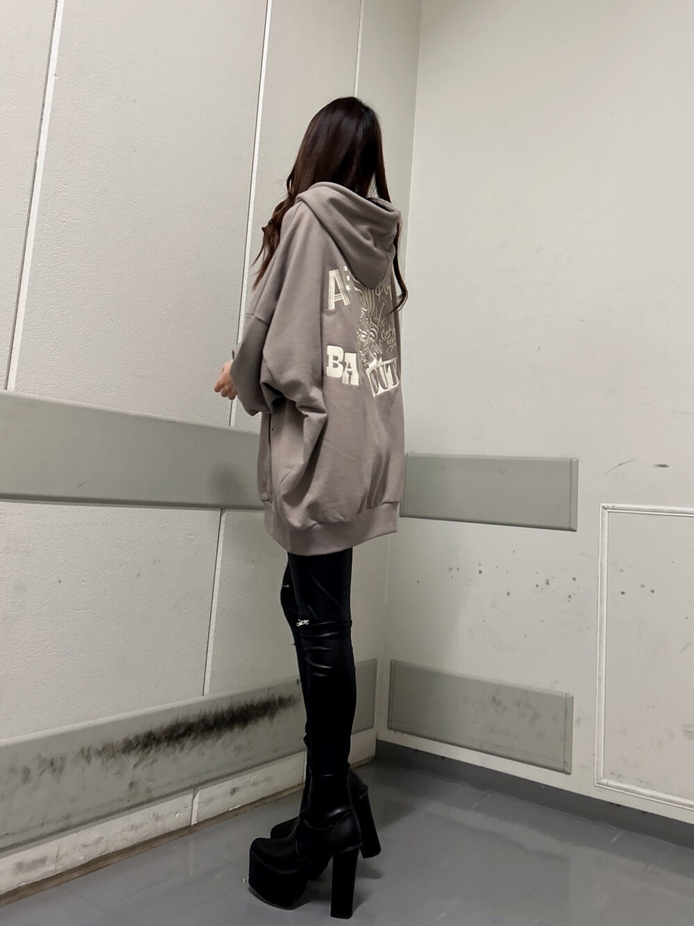 ブラック系のブーツ、ブラック系のその他パンツ、ベージュ系のパーカーを着用したレディースの冬コーディネートの2枚目の写真