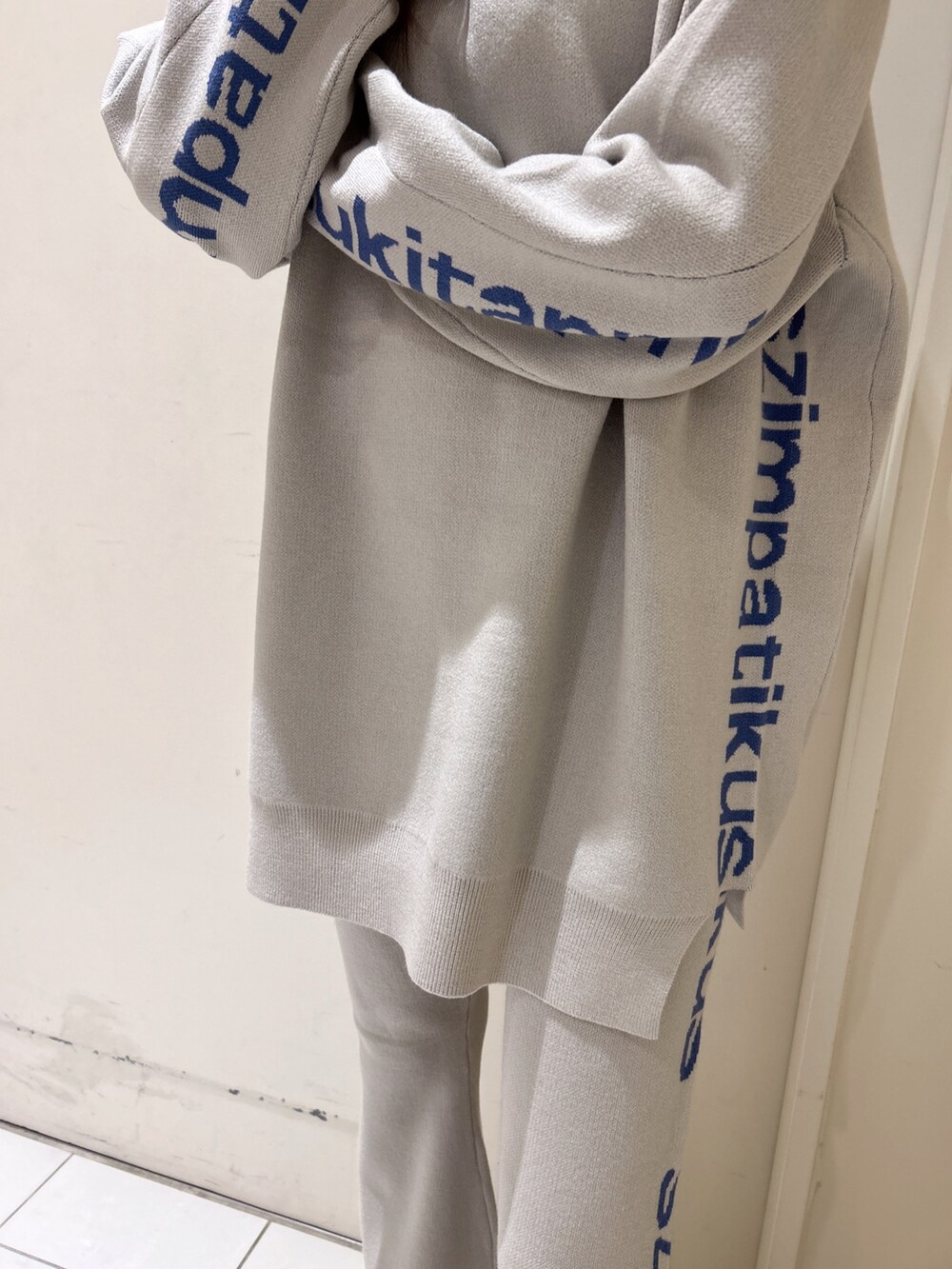 ホワイト系のニット/セーター、オレンジ系のその他パンツ、ブラック系のブーツを着用したレディースの冬コーディネートの7枚目の写真