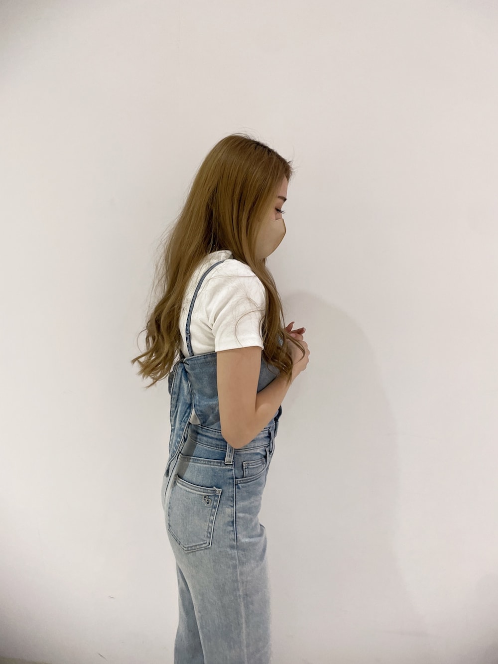 ブルー系のサロペット/オーバーオール、ホワイト系のTシャツ/カットソー、ブラック系のバックパック/リュックを着用したレディースの春コーディネートの6枚目の写真