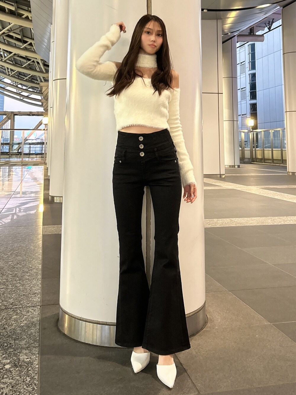 ホワイト系のムートンコート、ホワイト系のニット/セーター、ブラック系のデニムパンツを着用したレディースの秋コーディネートの5枚目の写真