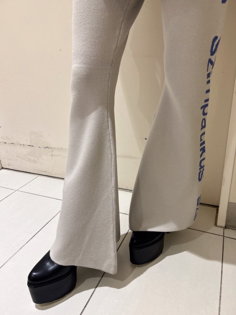 ホワイト系のニット/セーター、オレンジ系のその他パンツ、ブラック系のブーツを着用したレディースの冬コーディネートの8枚目の写真