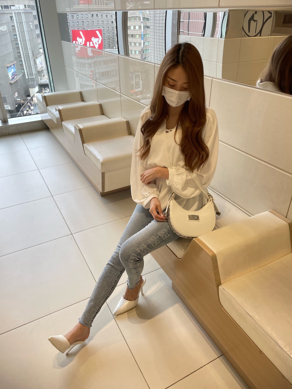 ホワイト系のシャツ/ブラウス、ブルー系のデニムパンツ、ホワイト系のパンプスを着用したレディースの冬コーディネートの3枚目の写真