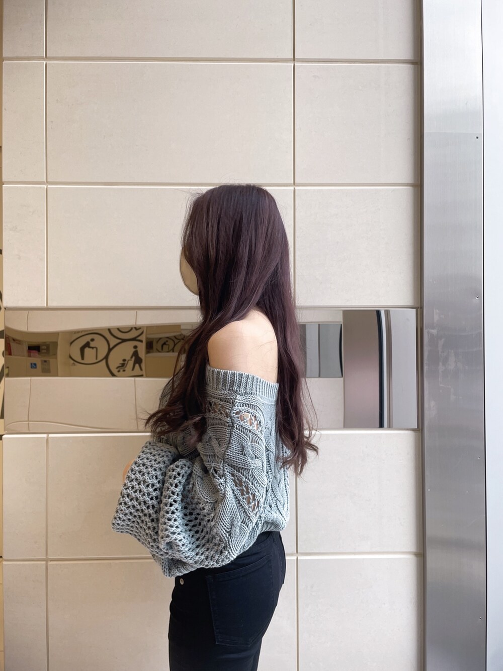 オレンジ系のニット/セーター、ブラック系のデニムパンツ、ホワイト系のパンプスを着用したレディースの冬コーディネートの4枚目の写真