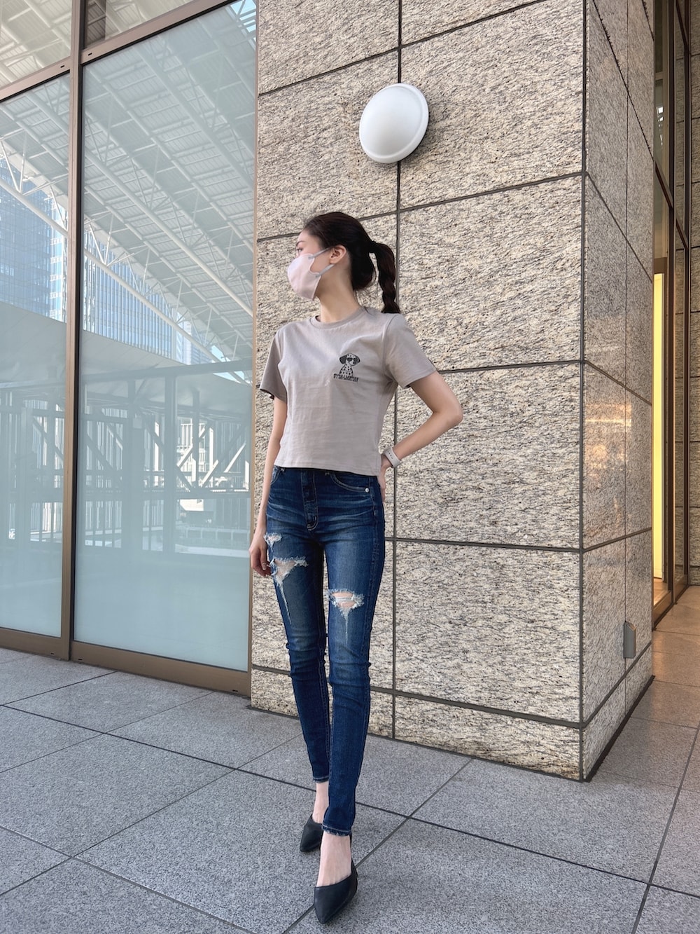 ベージュ系のTシャツ/カットソー、ブルー系のデニムパンツ、ホワイト系のパンプスを着用したレディースの夏コーディネートの2枚目の写真