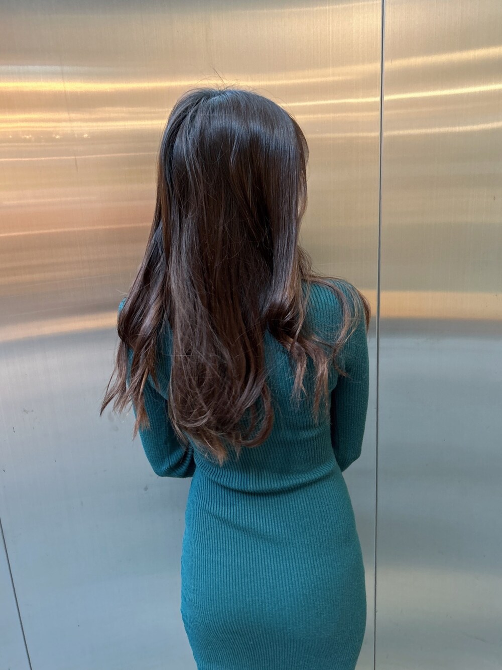 グリーン系のワンピース、ブラック系のパンプスを着用したレディースの秋コーディネートの6枚目の写真