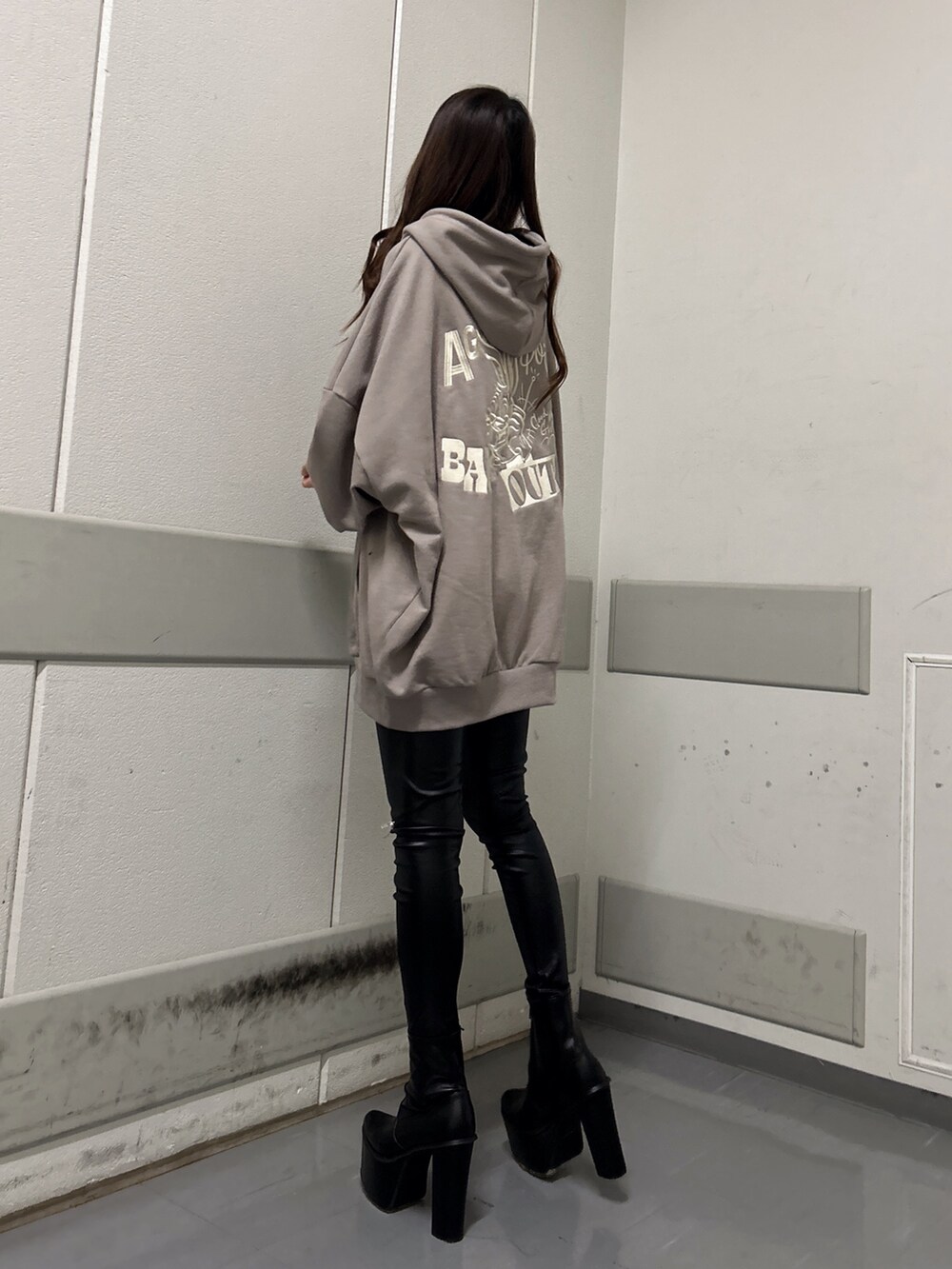 ブラック系のブーツ、ブラック系のその他パンツ、ベージュ系のパーカーを着用したレディースの冬コーディネートの3枚目の写真