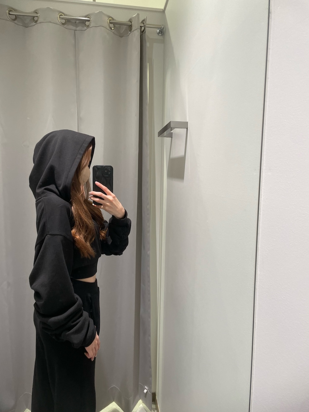 ホワイト系のスニーカー、ブラック系のスウェットパンツ、ブラック系のパーカーを着用したレディースの冬コーディネートの4枚目の写真