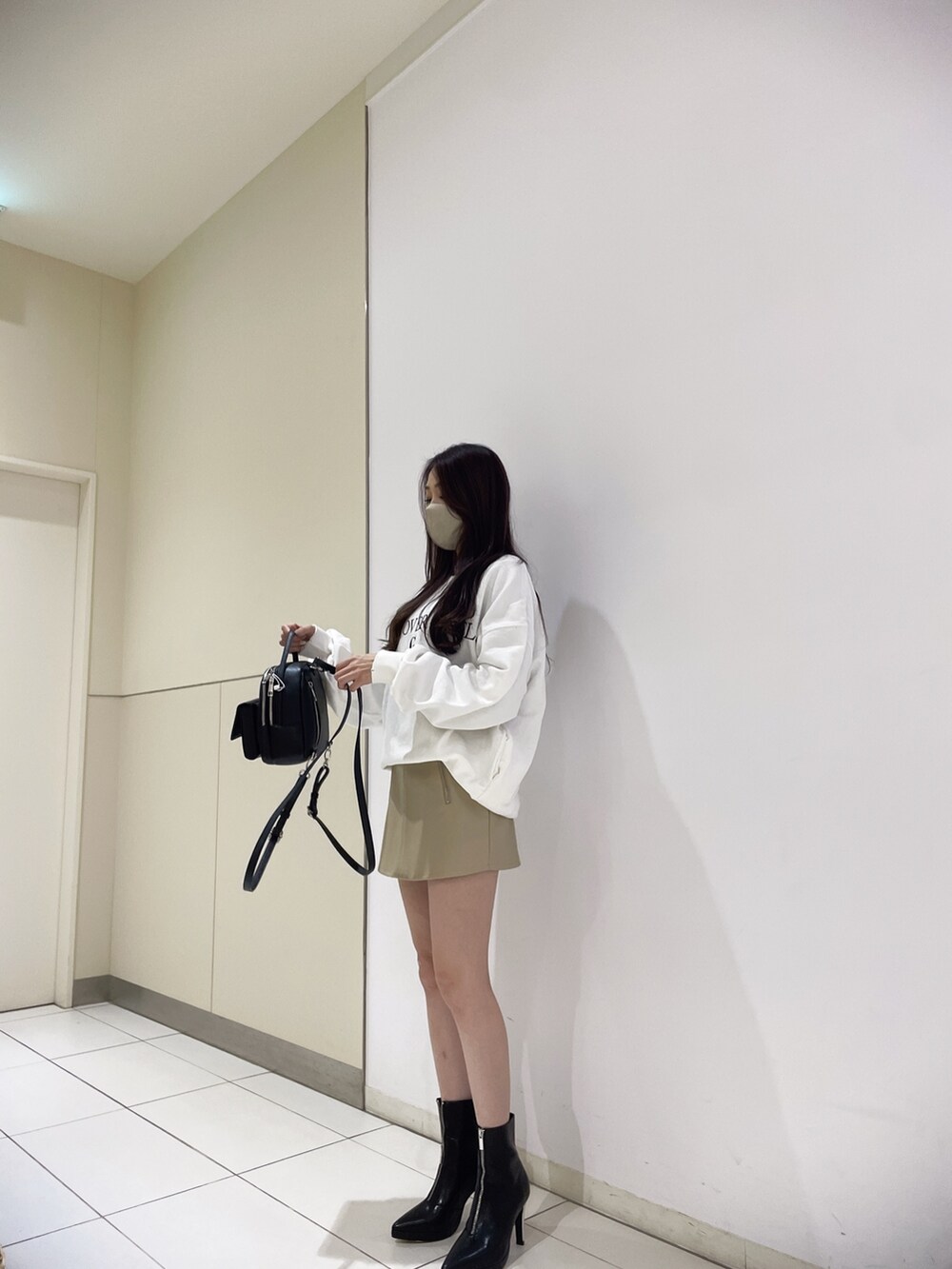 ホワイト系のスウェット、ホワイト系のスカート、ベージュ系のスカートを着用したレディースの冬コーディネートの2枚目の写真