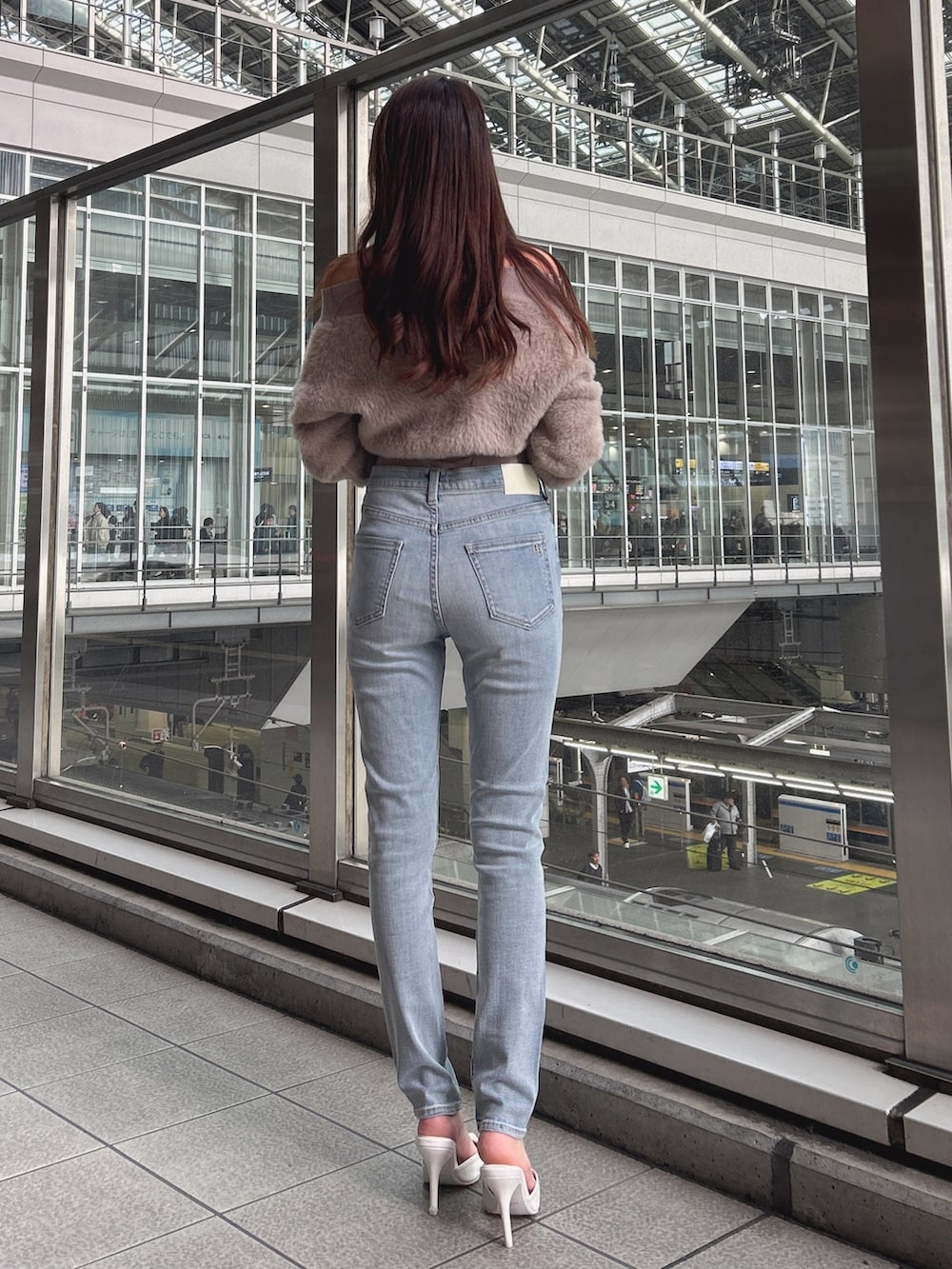 ベージュ系のニット/セーター、ブルー系のデニムパンツ、ブラック系のパンプスを着用したレディースの秋コーディネートの3枚目の写真