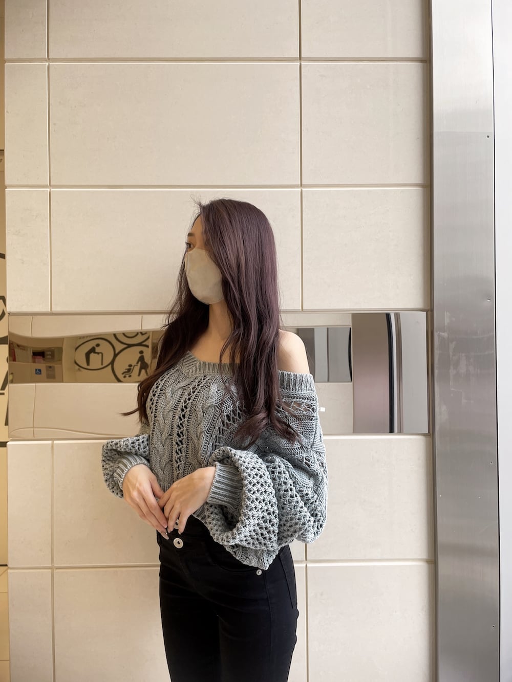 オレンジ系のニット/セーター、ブラック系のデニムパンツ、ホワイト系のパンプスを着用したレディースの冬コーディネートの3枚目の写真