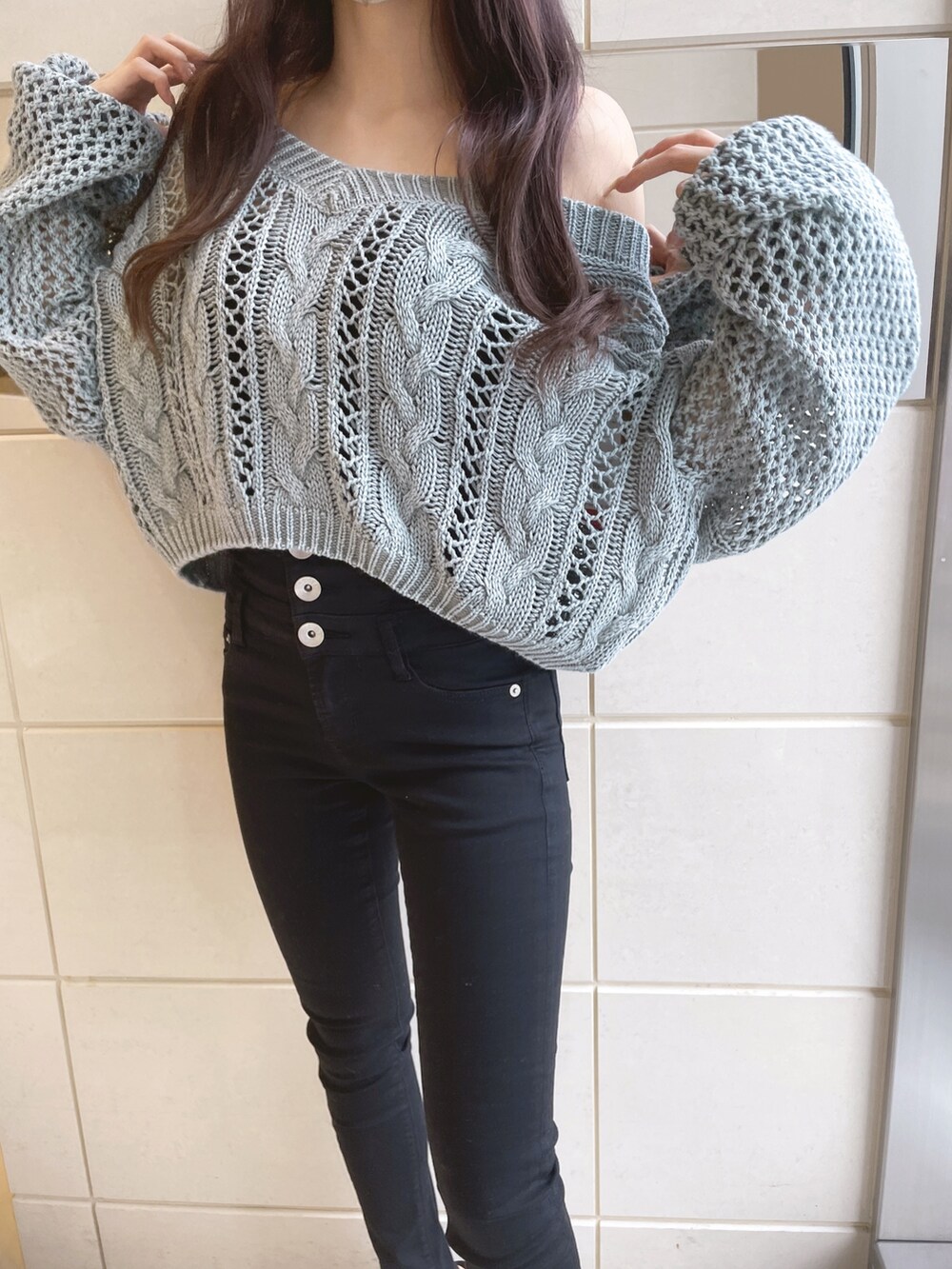 オレンジ系のニット/セーター、ブラック系のデニムパンツ、ホワイト系のパンプスを着用したレディースの冬コーディネートの5枚目の写真