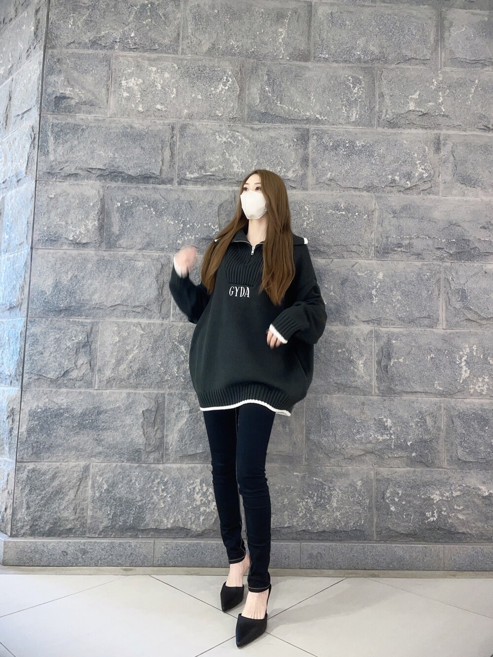 ホワイト系のニット/セーター、ブラック系のデニムパンツ、ホワイト系のパンプスを着用したレディースの冬コーディネートの2枚目の写真