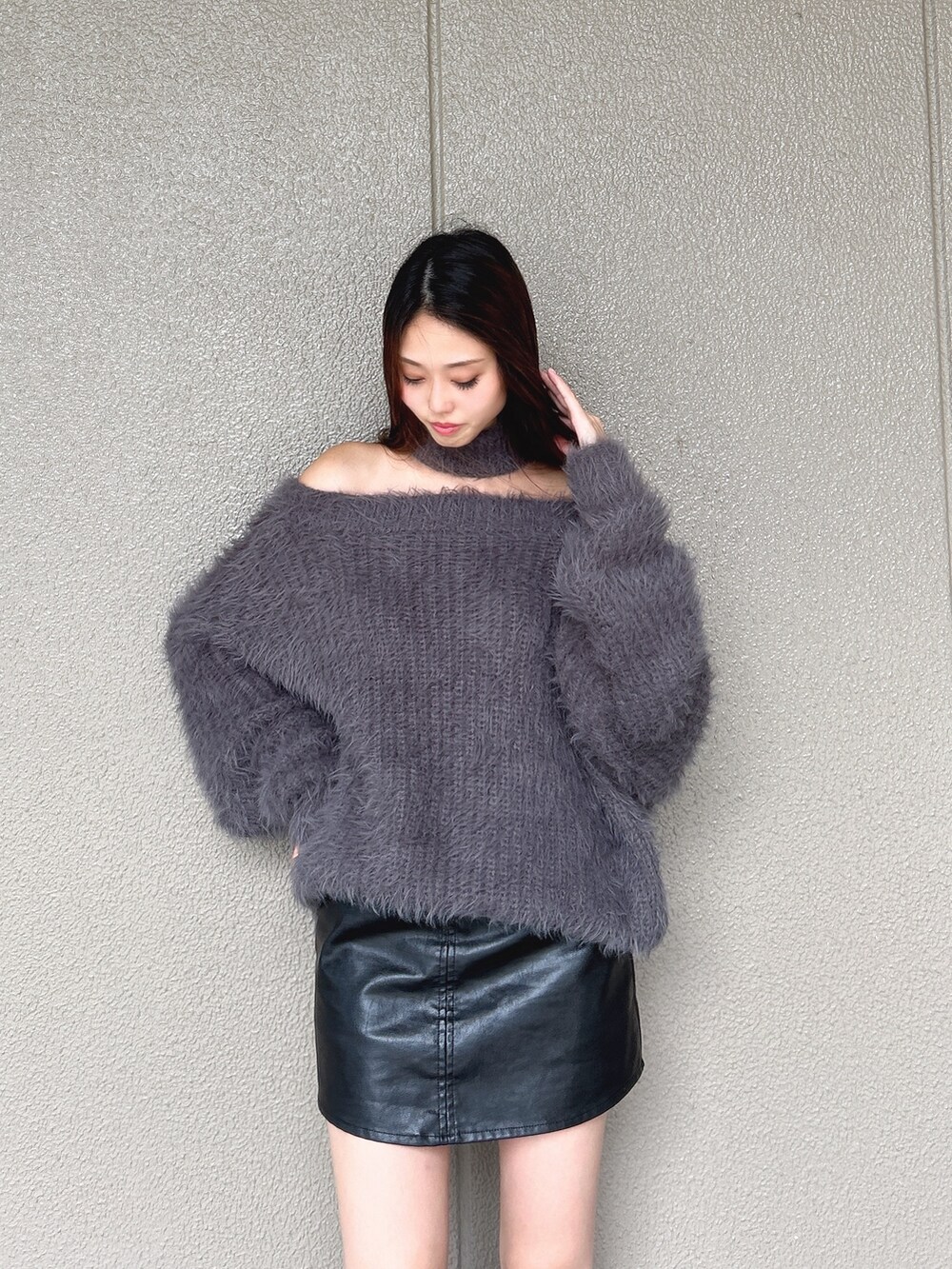 グレー系のニット/セーター、ブラック系のスカート、ブラック系のブーツを着用したレディースの秋コーディネートの5枚目の写真