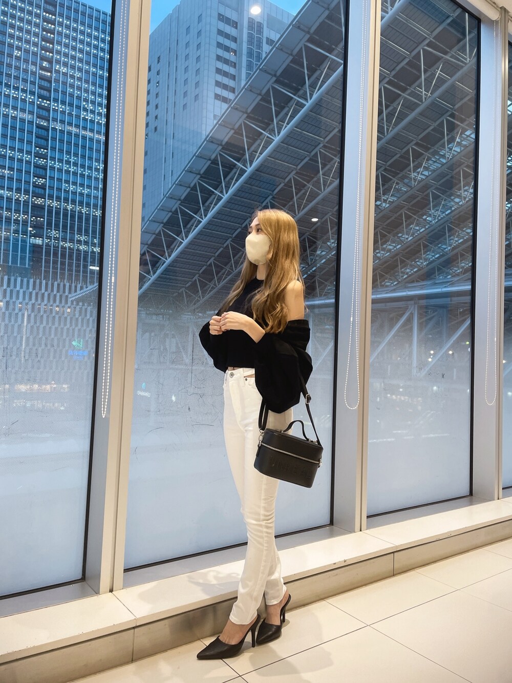 ブラック系のカーディガン/ボレロ、ホワイト系のデニムパンツ、ホワイト系のパンプスを着用したレディースの春コーディネートの3枚目の写真