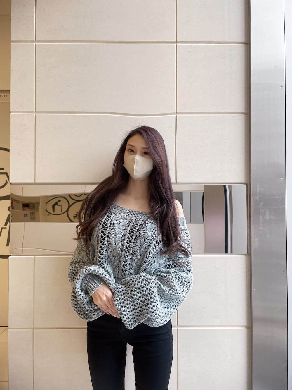 オレンジ系のニット/セーター、ブラック系のデニムパンツ、ホワイト系のパンプスを着用したレディースの冬コーディネートの2枚目の写真