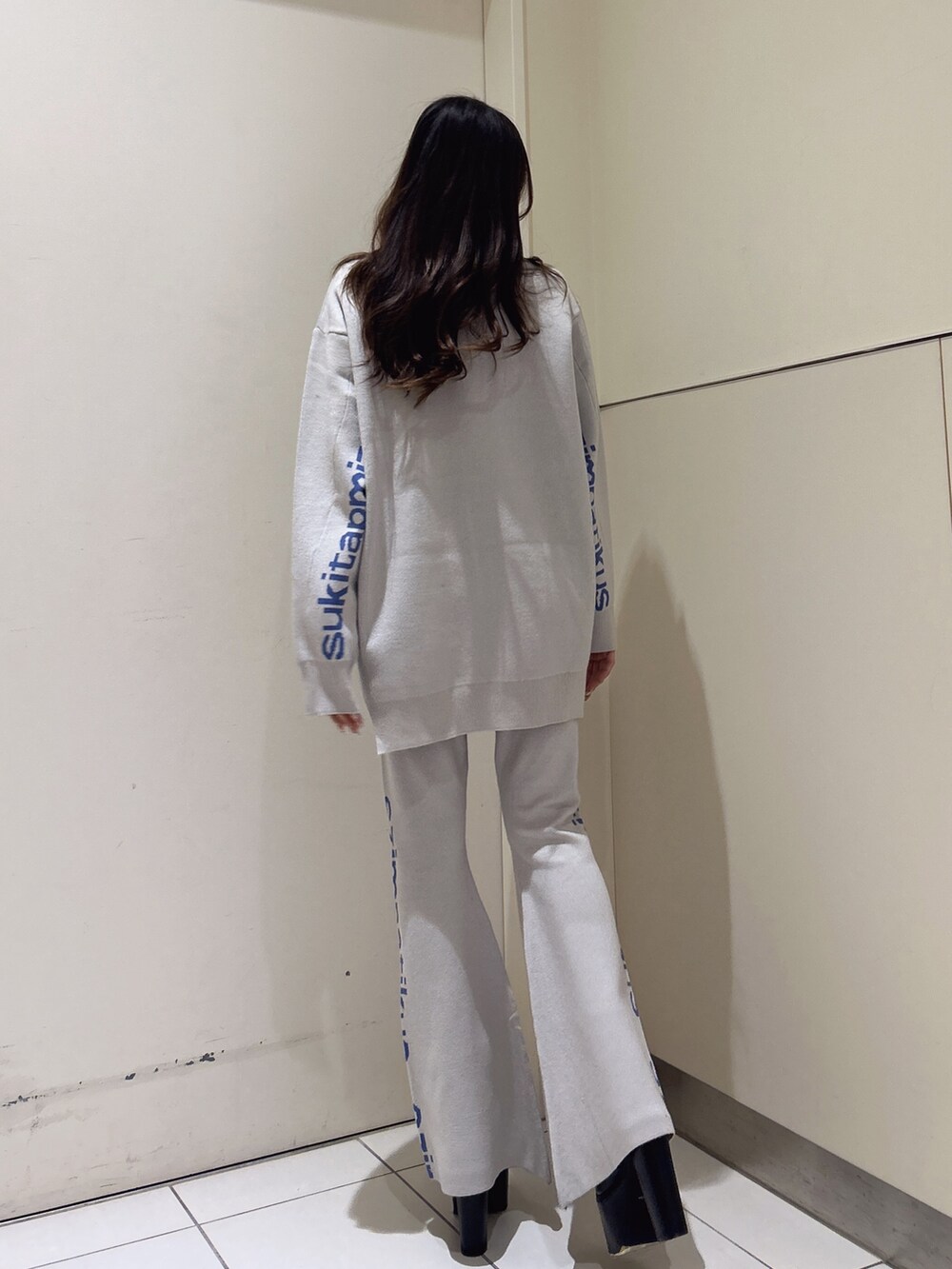 ホワイト系のニット/セーター、オレンジ系のその他パンツ、ブラック系のブーツを着用したレディースの冬コーディネートの4枚目の写真