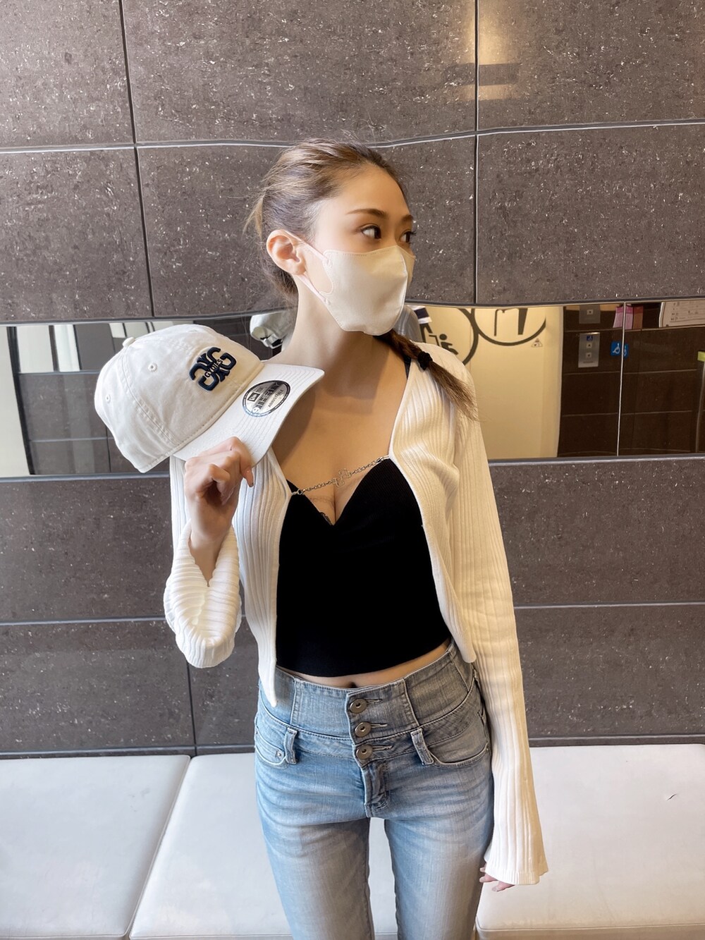 ホワイト系のチューブトップ、ブラック系のカーディガン/ボレロ、ブルー系のデニムパンツを着用したレディースの夏コーディネートの2枚目の写真